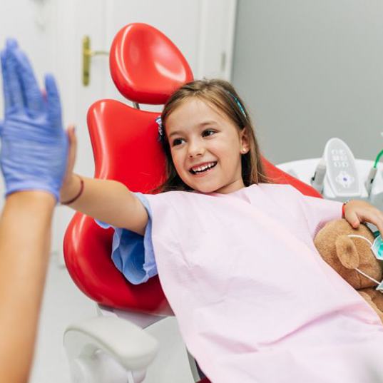 Child high-fiving dental team member