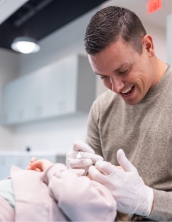 Pediatric dentist smiling with young child