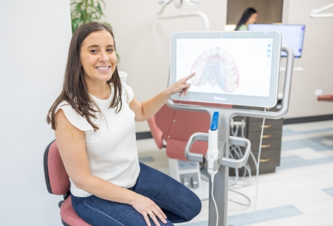 Pediatric dentist and dental patient looking at digital impressions on chairside computer screen