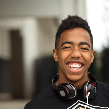 Teenage boy smiling while wearing headphones 