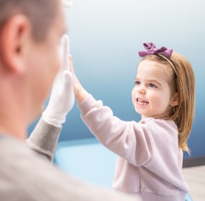 Young girl in light blue hat grinning